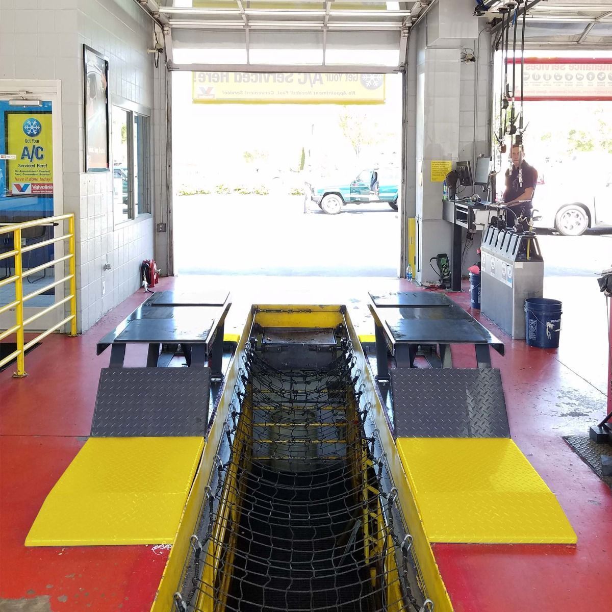 BendPak P-9000LT low-rise pit lift in an oil change service bay