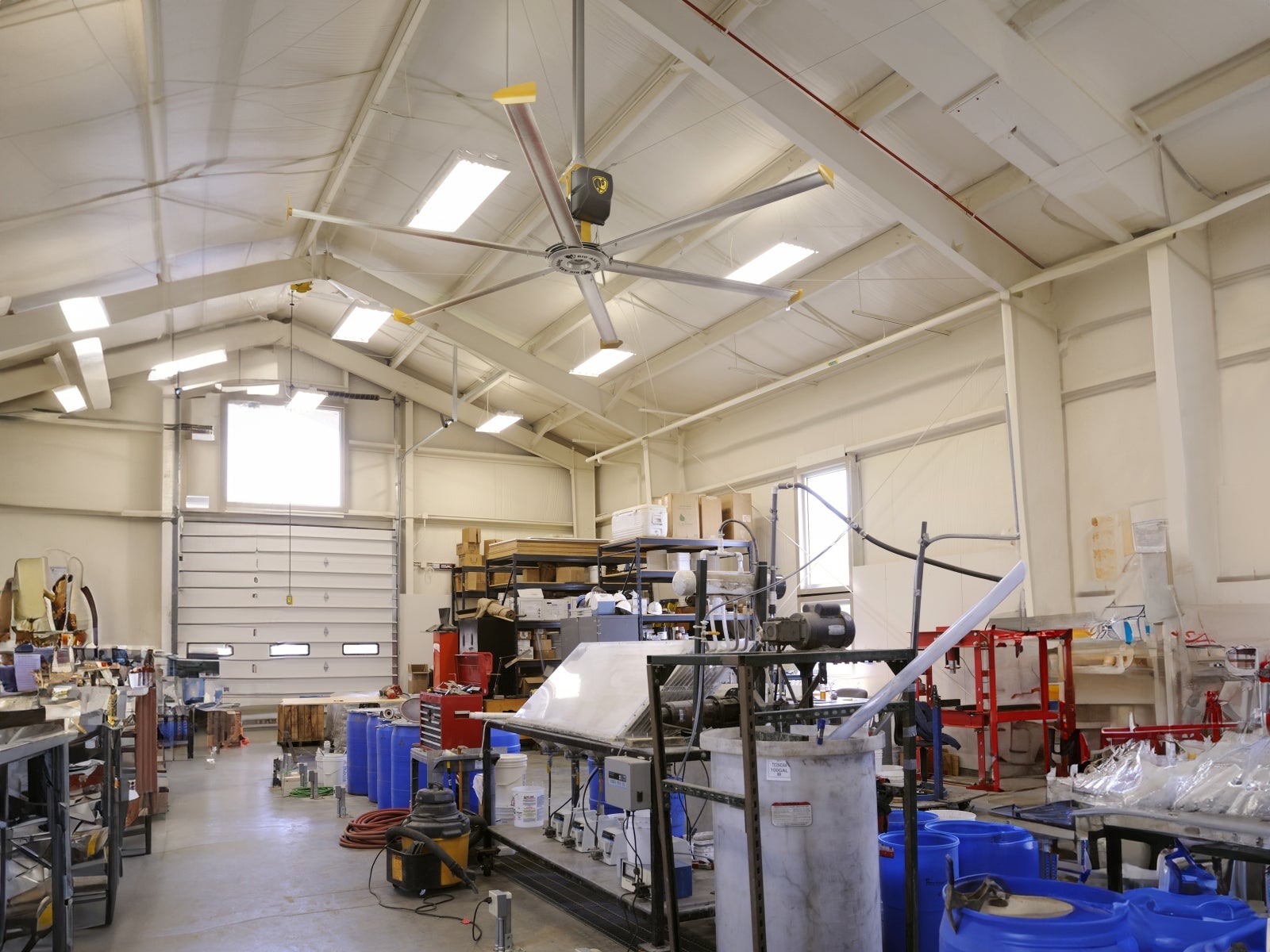 Wide professional shop interior with overhead HVLS fan